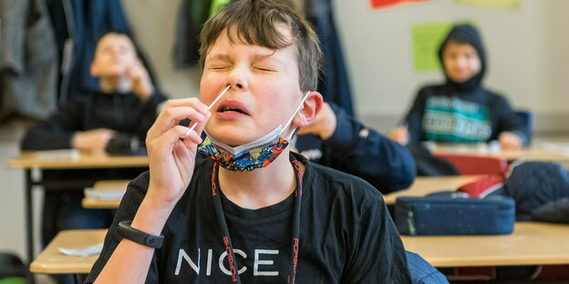 Ein Schüler nimmt mit einem Stäbchen ein abstrich in der Nase