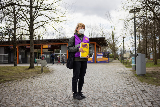 Eine Frau mit der typischen lila Weste der ehrenamtlichen Unterschtiftensammler des Volksbegehren Deutsche Wohnen & Co enteignen steht in Berlin im Bezirk Marzahn-Hellersdorf