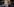 Erna Solberg trägt ihre Mundnasenschutz-Maske unter dem Kinn und blickt in die Ferne
