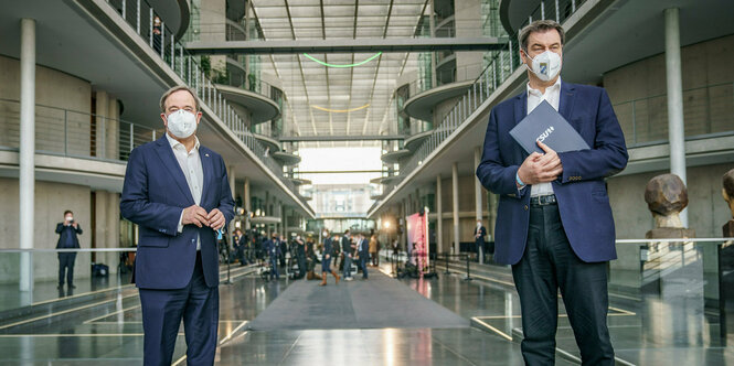 Armin Laschet und Markus Söder mit Maske im Flur nebeneinander