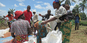 Bewohner*innen von Kananga bedienen sich an Bohnenrationen des Welternährungsprogramms