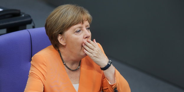 Angela Merkel mit Hand vorm Mund