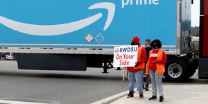 Arbeiter mit einem Gewrkschaftsbanner vor einem Amazon-Lastwagen bei der Kampagne in Bessemer