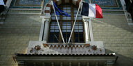 Eine französische und europäische Flagge über einem Portal.