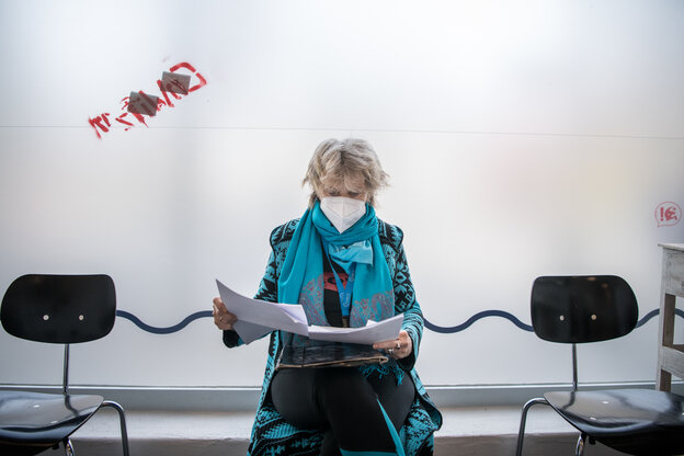 Patientin sitzt mit Maske im Wartezimmer Patientin sitzt mit Maske im Wartezimmer