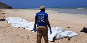 Ein IOM-Mitarbeiter an einem Strand.