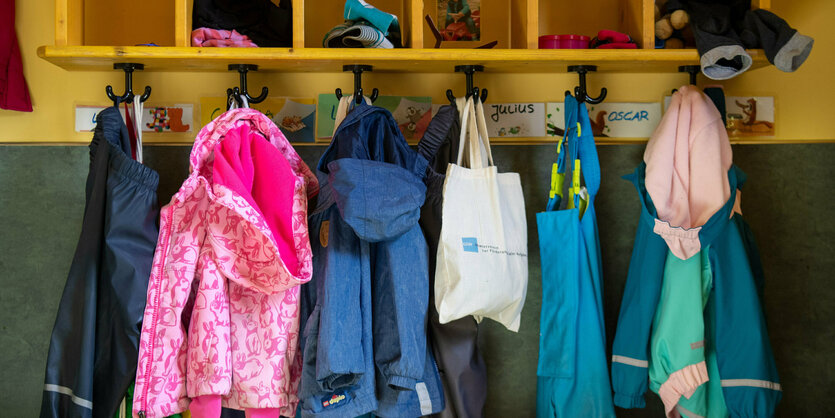 Jacken und Taschen hängen im Eingangsbereich in einem Kindergarten