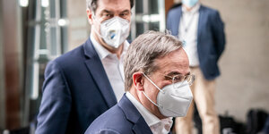 Armin Laschet und hinter ihm Markus Söder auf dem Weg zu einer Pressekonferenz. Beide tragen Maske