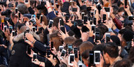 Viele Menschen halten während eines Events halten ihre Smartphones hoch