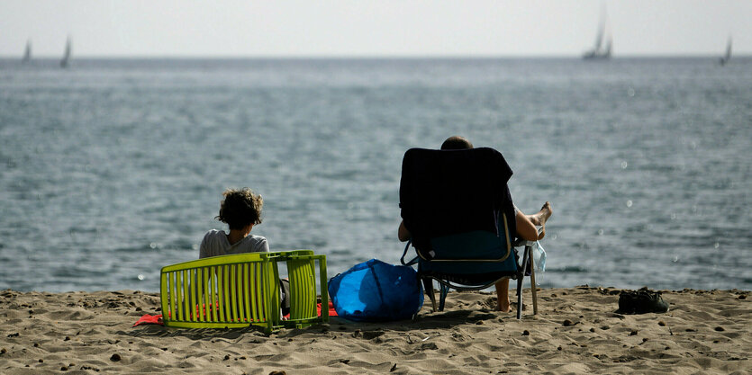 Menschen sonnen sich am Strand von Pollença auf Mallorca