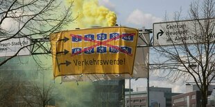 Protest auf einer schilderbrücke über einer Straße.