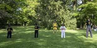 Kinder im Park von hinten, die auf ihren Trainer schauen