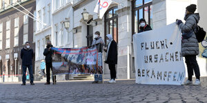 Fluchtursachen bekämpfen steht auf dem Transparent das Demonstrierende vor dem Konzerthaus Die Glocke halten. Drinnen tagt das Bremer Landgericht