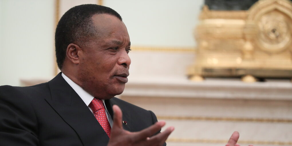 Sassou Nguesso im Anzug vor Gold-Dekor