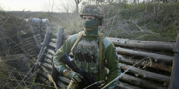 Soldat in Tarnkleidung steht im Wald