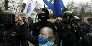 Eine Demonstrantin hält die EU-Flagge vor der russischen Botschaft in Prag hoch. Neben ihr ein polizeiliches Aufgebot
