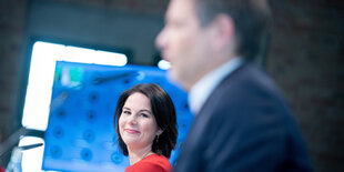 Annalena Baerbock und Robert Habeck bei einer Pressekonferenz, er ist unscharf, sie scharf gestellt