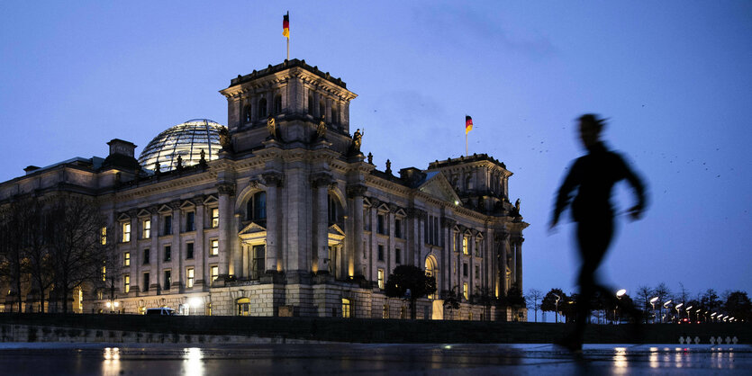 Eine joggende Person vor dem Reichstag.