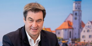 Markus Söder lächelt vor München-Kulisse