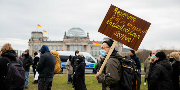 Ein Mann steht bei einer Kundgebung gegen die Corona-Maßnahmen vor dem Reichstagsgebäude