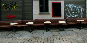 Leere Tische und Bänke stehen vor einer Kneipe in der Altstadt von Halle/Saale