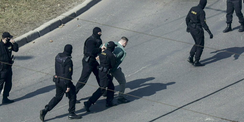 Polizisten führen einen Gefangenen ab