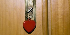 Ein Schlüssel mit herzförmigen Schlüsselanhänger steckt in einem Türschloss