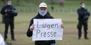 Mann hält ein Schild mit "Lügenpresse"