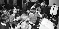 Lokaler Computerclub in der DDR in der Achzigern - schwarz-Weiß Foto: Männer blicken gemeinsam auf einen Computermonitor