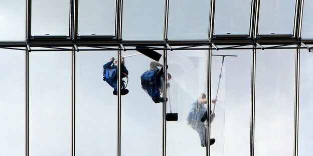 Gebäudereiniger putzen ein Glasdach in Berlin Fensterputzer auf einem Glasdach