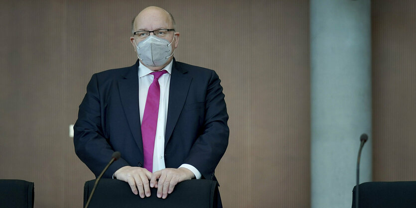 Petr Altmaier mit Maske lehnt sich an einen Stuhl