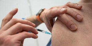 Eine Impfspritze in einem Oberarm