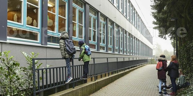 Zwei Schüler gucken von außen in einen Klassenraum