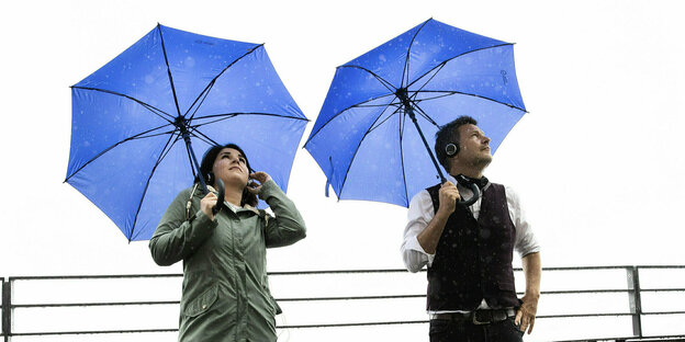 Annalena Baerbock und Robert Habeck mit blauen Regenschirmen