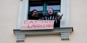 Ein Mann und eine Frau nehmen von einem Fenster aus an einer Demonstration des Bündnisses "Gemeinsam gegen Verdrängung und #Mietenwahnsinn" gegen das Urteil des Bundesverfassungsgerichts zum Mietendeckel in Berlin teil. Das Gericht hatte den