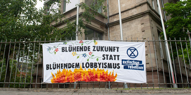 Ein Plakat mit der Aufschrift «Blühende Zukunft statt blühendem Lobbyismus» von Aktivisten der Umweltschutzbewegung «Extinction Rebellion» (XR) hängt an einem Zaun