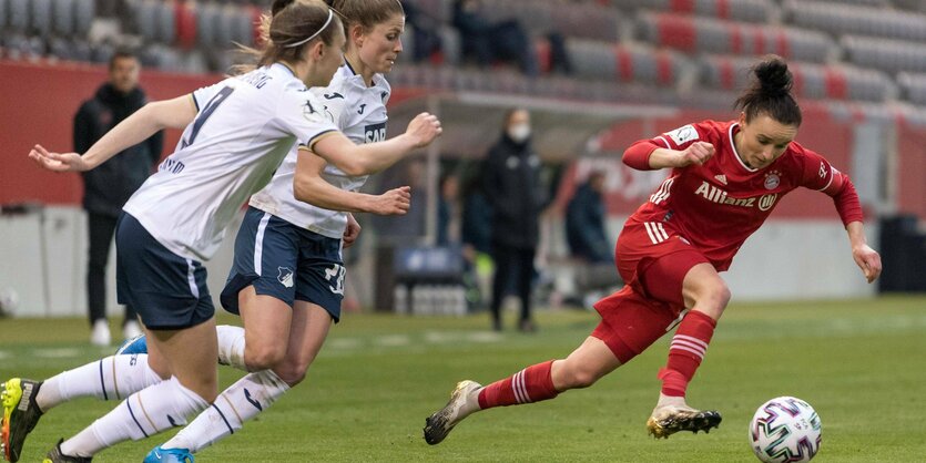 Bayern-Spielerin enteilt mit dem Ball zwei Gegenspielerinnen