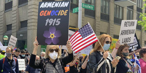 Menschen mit Mundschutz, Schildern und US-Flagge bei einer Kundgebung in New York