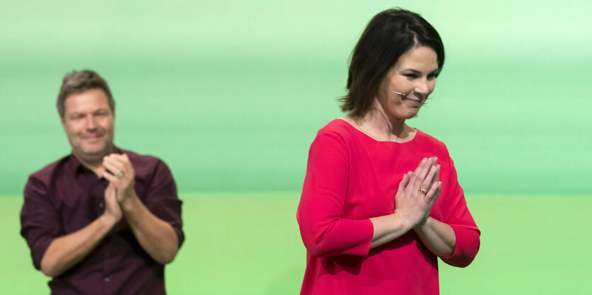 Annalena Baerbock neben Robert Habeck vor einer grünen Wand