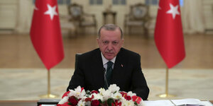 Der türkische Präsident Erdogan inmitten zweier Türkeiflaggen