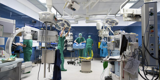 OP-Personal und ein OP-Reinigungsteam arbeiten nach einer Operation in einem Operationssaal am Agaplesion Diakonieklinikum in Hamburg.