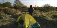 Hassan steht hinter seinem Zelt am Rand von Calais, er will nach England.