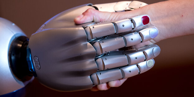 Roboterhand schüttelt Menschenhand