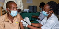 Eälterer Mann erhält in einem Krankenhaus in Kigali, Ruanda eine Covid-19 Impfung