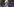 Joe Biden vor US-Flaggen hebt den zeigefinger der rechten Hand