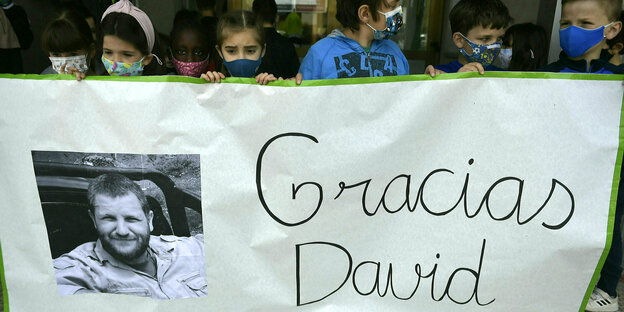 Kinder halten ein Banner mit der Aufschrift "Gracias David" und einem Foto des ermordeten spanischen Journalisten David Beriáin