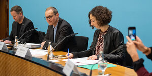 Klaus Lederer (Die Linke), Kultursenator von Berlin, Michael Müller (SPD), Berlins Regierender Bürgermeister, und Ramona Pop (Bündnis 90/Die Grünen), Wirtschaftssenatorin von Berlin, sitzen bei einer Pressekonferenz auf einem Podium