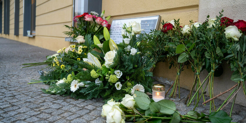 Blumen und Kerzen vor einem Haus