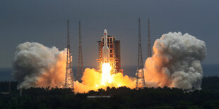 Rakete startet, man siet unten Feuer und daneben Wolken