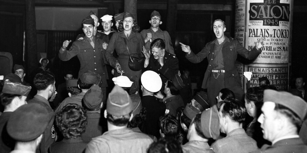 Schwarzweißfoto von singende Soldaten.